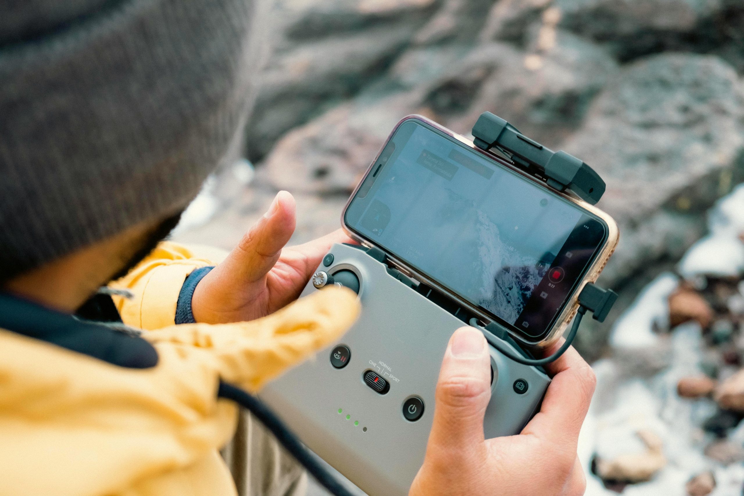 Close-up of a person controlling a drone with a smartphone in Heroica Veracruz.